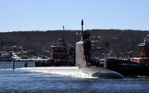 A submarine with decorations emerges from water.